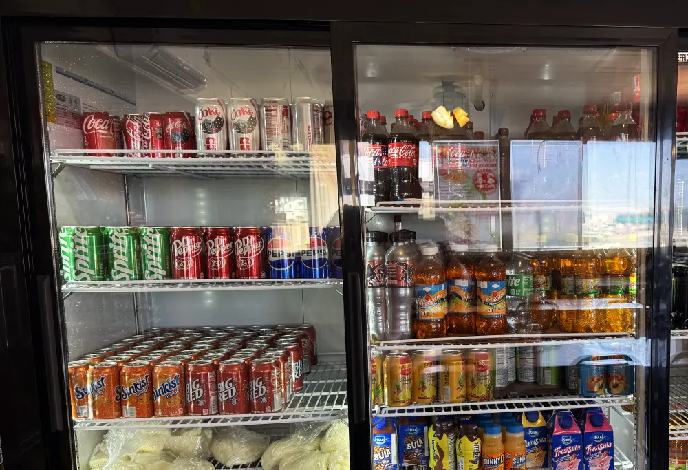 The three-door cooler in the dining room, stocked with Mexican sodas, juices and bagged quesillo on the bottom shelf.